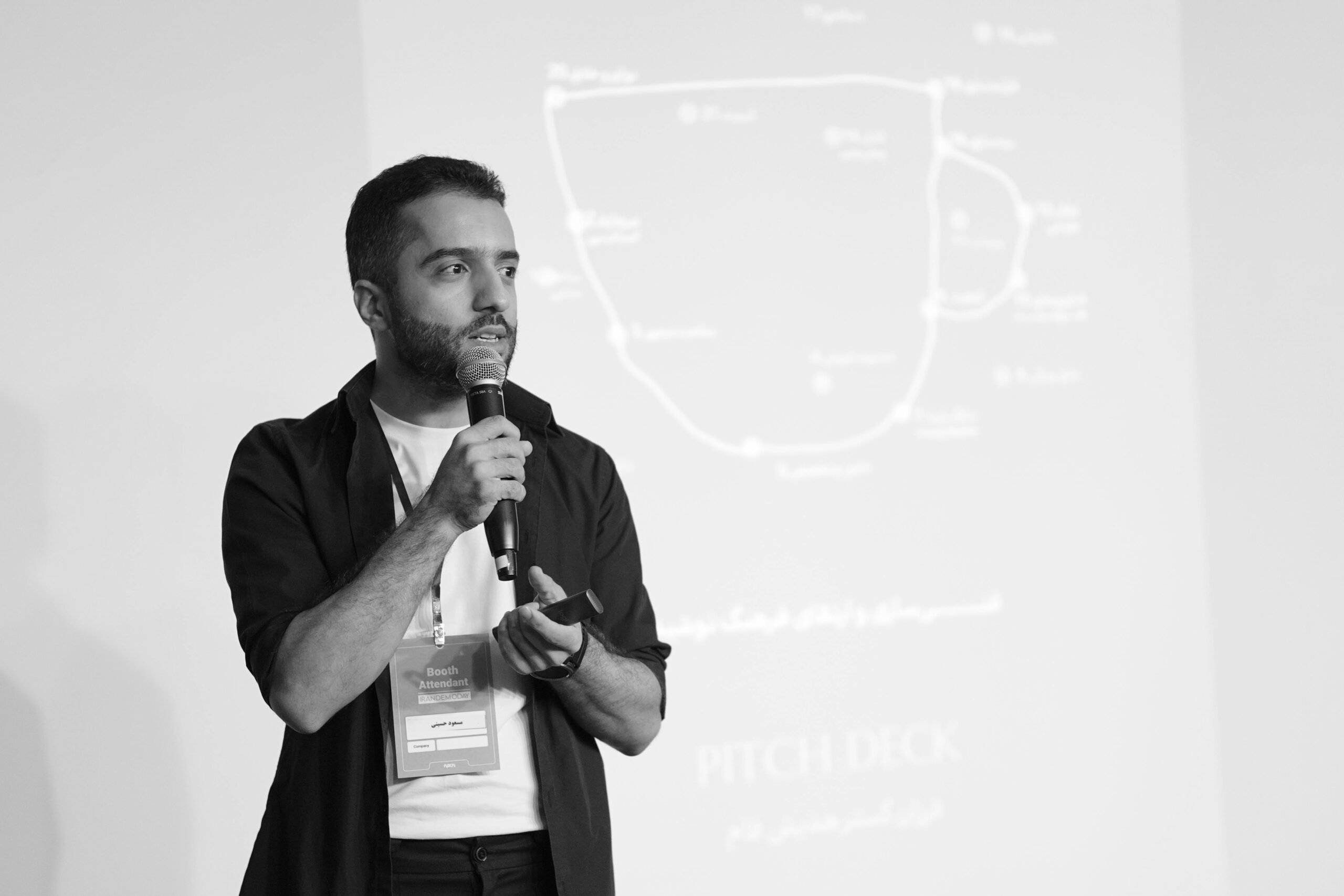 Man speaking into a microphone during a business seminar presentation.